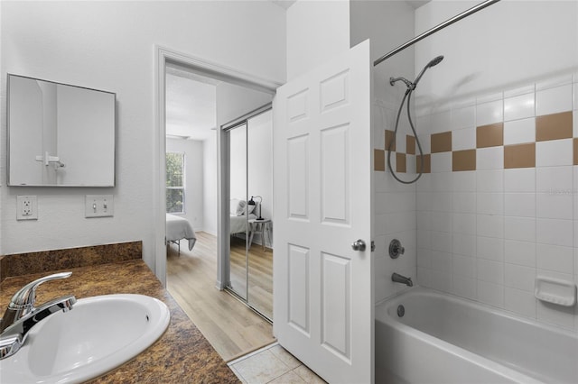 bathroom featuring tiled shower / bath, hardwood / wood-style floors, and vanity