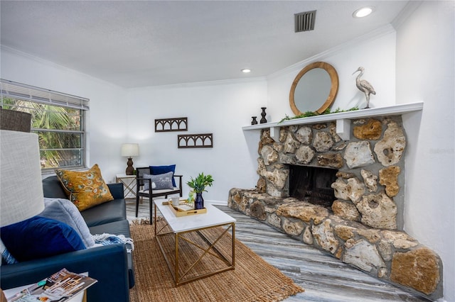 living room featuring crown molding, a fireplace, and wood-type flooring