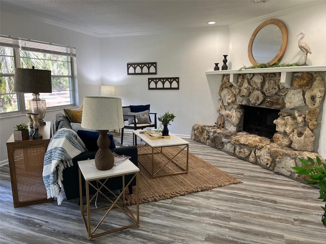 living room with a textured ceiling, crown molding, a fireplace, and hardwood / wood-style floors