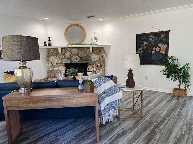 living room featuring a stone fireplace, dark hardwood / wood-style flooring, and crown molding