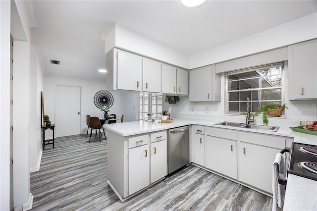 kitchen featuring dishwasher, kitchen peninsula, decorative backsplash, sink, and range with electric stovetop