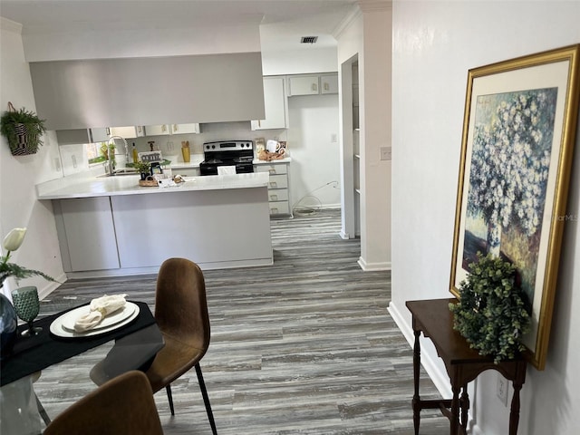 kitchen featuring kitchen peninsula, electric range, sink, gray cabinetry, and dark hardwood / wood-style flooring