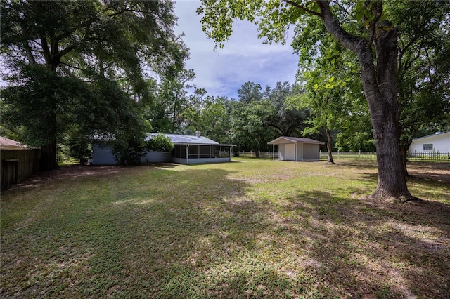 view of yard with a storage shed and a sunroom