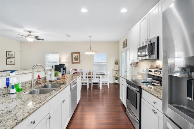 kitchen with sink, white cabinetry, decorative light fixtures, appliances with stainless steel finishes, and plenty of natural light