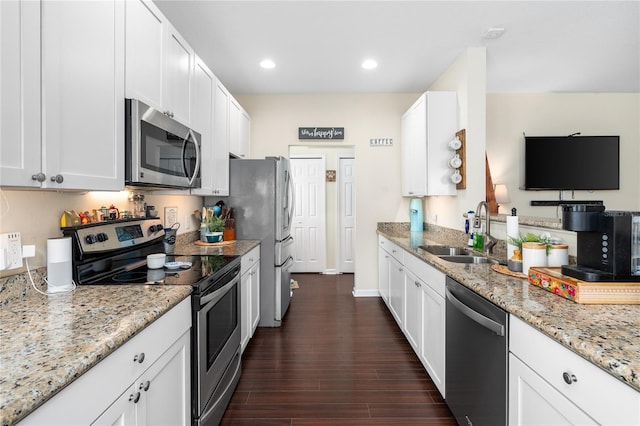 kitchen with sink, stainless steel appliances, dark hardwood / wood-style floors, light stone counters, and white cabinets