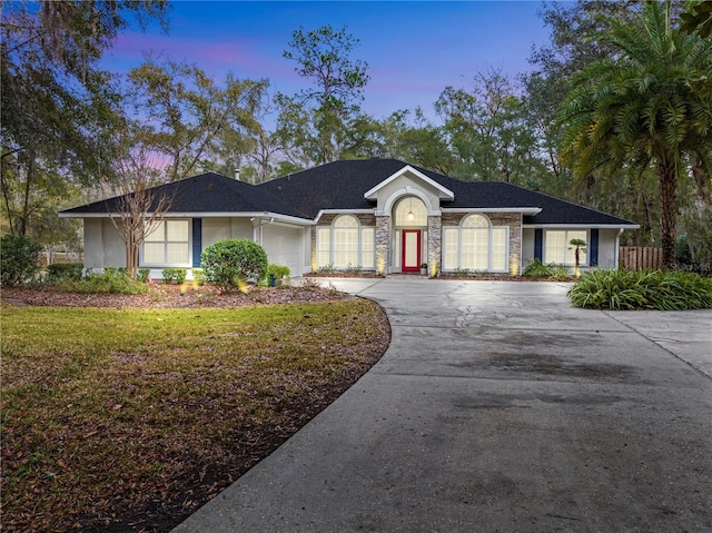 ranch-style house featuring a garage and a yard