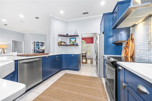 kitchen with light tile patterned floors, stainless steel appliances, blue cabinetry, wall chimney range hood, and crown molding