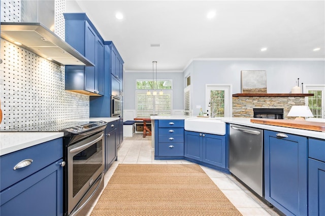 kitchen featuring backsplash, wall chimney range hood, hanging light fixtures, appliances with stainless steel finishes, and ornamental molding