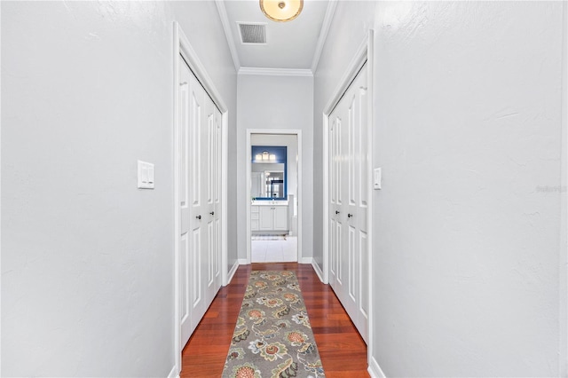 hall with dark wood-type flooring and ornamental molding