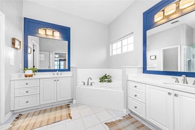 bathroom featuring tiled tub, tile patterned floors, and vanity