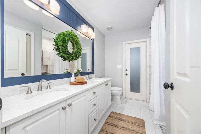 bathroom with toilet, tile patterned flooring, and vanity