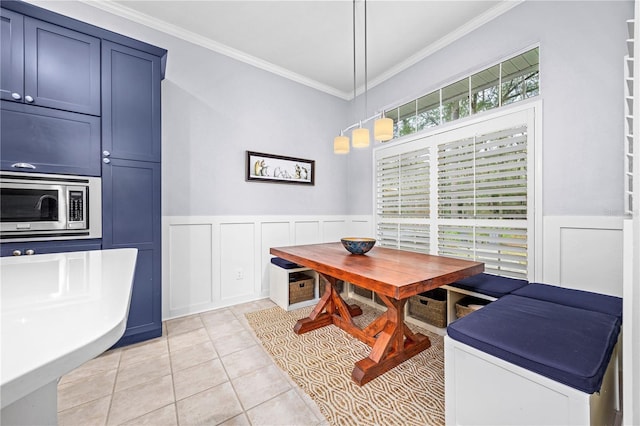 dining room featuring breakfast area, crown molding, and light tile patterned floors