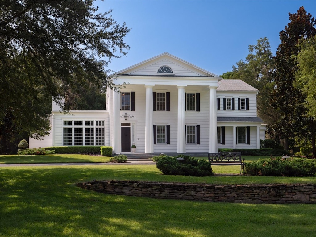 neoclassical home with a front lawn