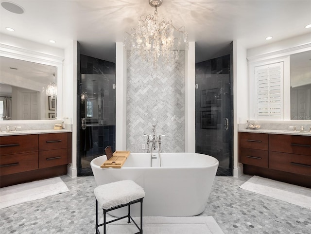 bathroom with vanity, separate shower and tub, tile walls, and a chandelier