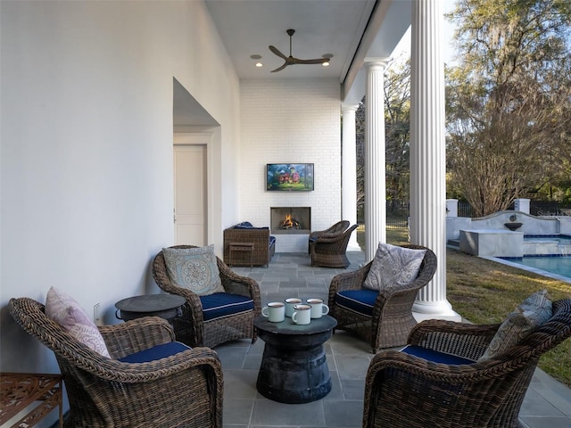 view of patio / terrace featuring a large fireplace and ceiling fan