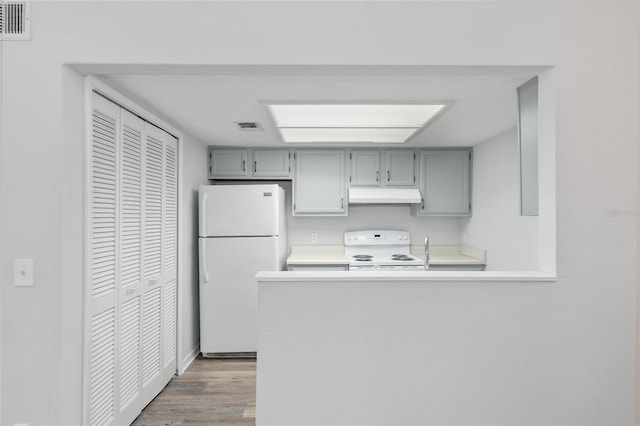 kitchen with gray cabinetry, white appliances, visible vents, and under cabinet range hood