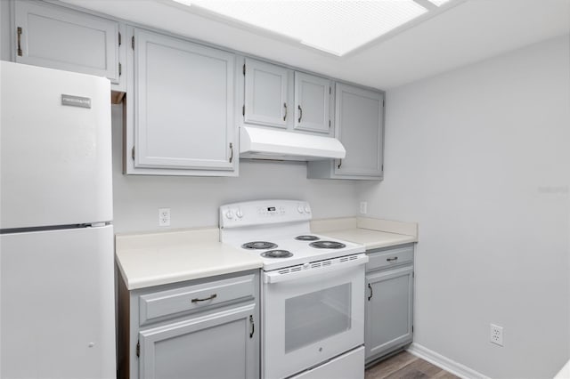 kitchen featuring white appliances, light countertops, under cabinet range hood, and gray cabinetry