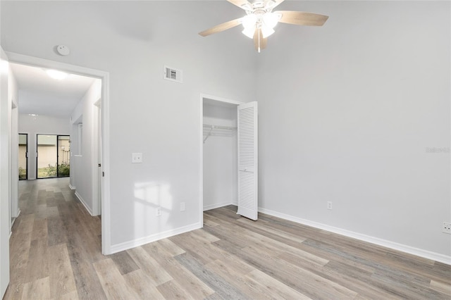 unfurnished bedroom with ceiling fan, visible vents, baseboards, light wood-style floors, and a closet