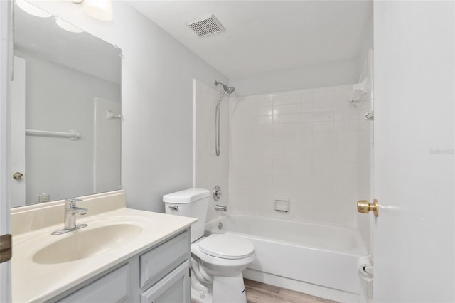 bathroom featuring visible vents, toilet, wood finished floors, vanity, and shower / bathing tub combination