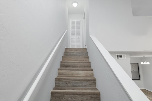 stairway featuring a chandelier and visible vents