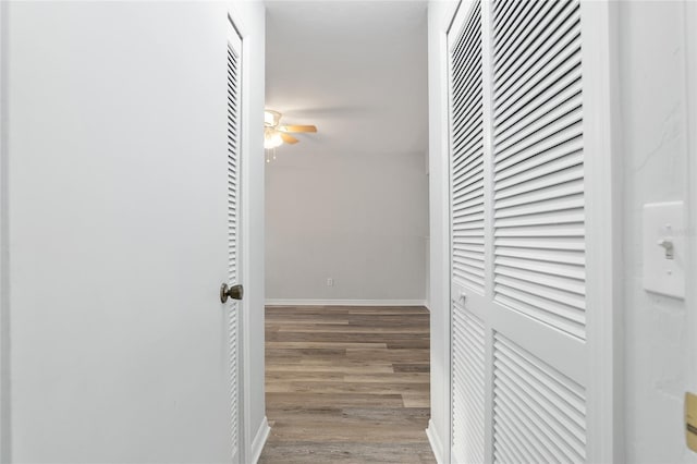 hall featuring baseboards and wood finished floors