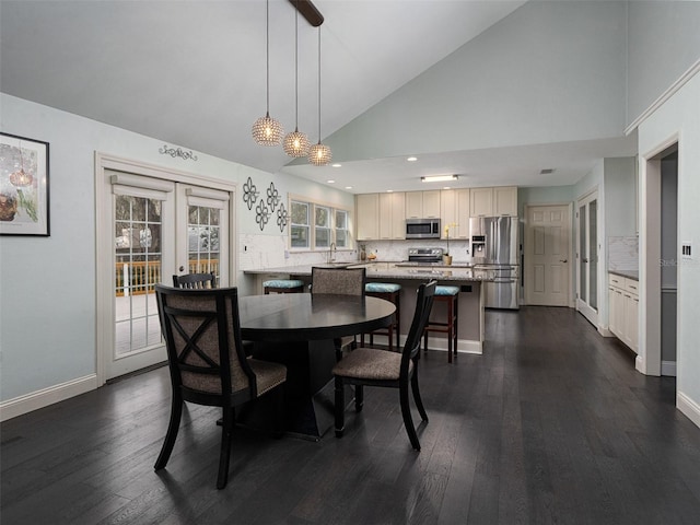 dining room with sink, dark hardwood / wood-style floors, high vaulted ceiling, and french doors