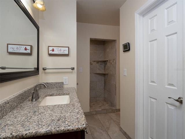 bathroom featuring vanity and tiled shower