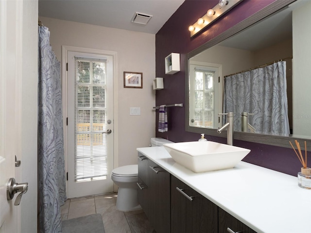 bathroom with tile patterned flooring, vanity, and toilet