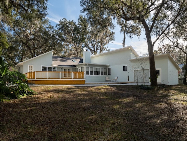 rear view of house with a sunroom and a deck