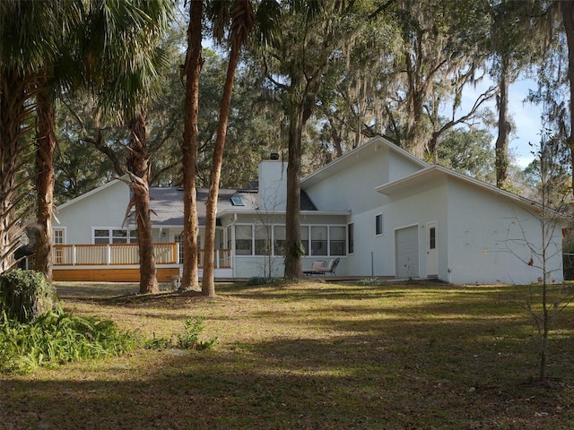 back of property featuring a yard and a sunroom