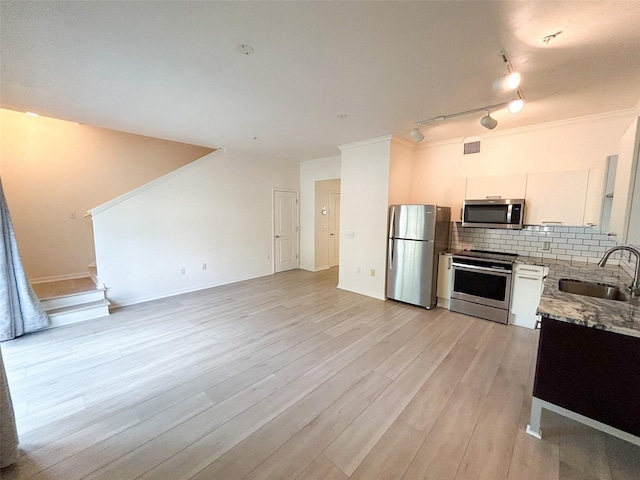 kitchen featuring sink, stainless steel appliances, light hardwood / wood-style floors, decorative backsplash, and white cabinets