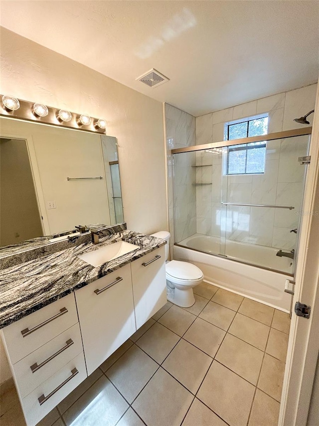 full bathroom with toilet, vanity, shower / bath combination with glass door, and tile patterned flooring