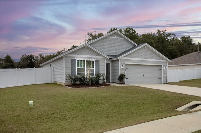 view of front of house featuring a garage and a lawn