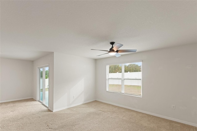 spare room with ceiling fan and light carpet