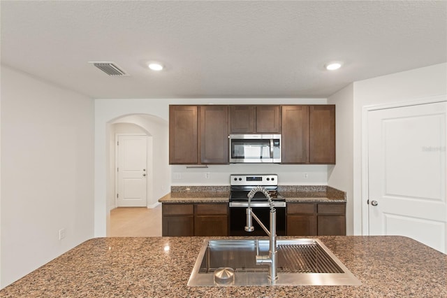 kitchen featuring sink, stainless steel appliances, and dark brown cabinets