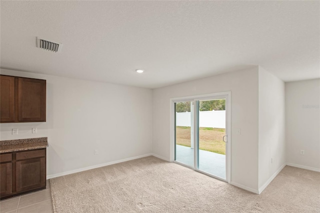 interior space with light carpet and a textured ceiling