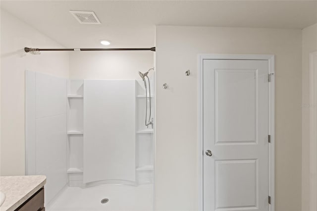 bathroom with walk in shower and vanity