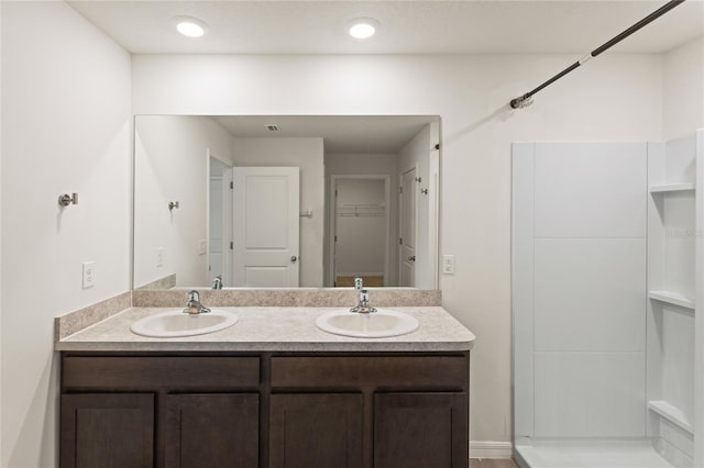 bathroom featuring a shower and vanity