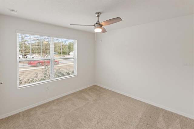 unfurnished room featuring ceiling fan and carpet