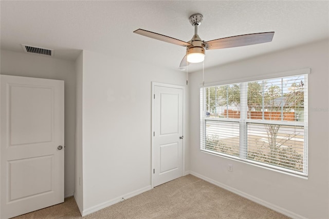 empty room featuring light carpet and ceiling fan