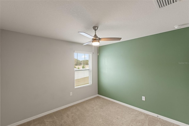 carpeted empty room featuring ceiling fan and a textured ceiling