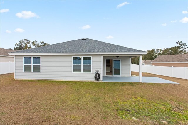 rear view of property featuring a patio area and a yard