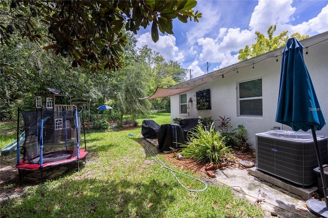 view of yard featuring a trampoline and cooling unit