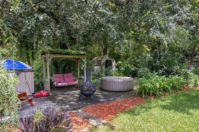 view of yard with an outdoor fire pit, a hot tub, and a patio