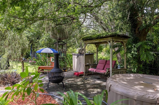 view of patio with a hot tub and a fire pit