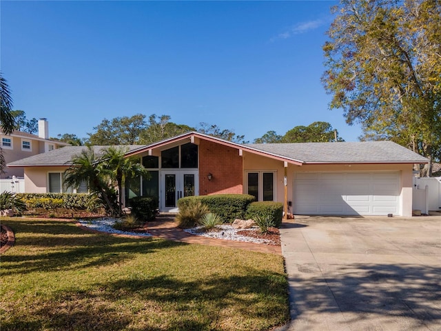 ranch-style home with a garage, a front lawn, and french doors