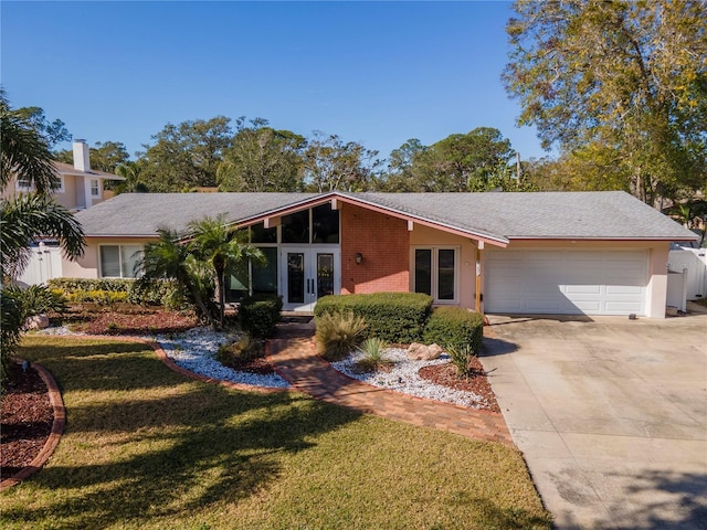 single story home featuring a garage, a front lawn, and french doors