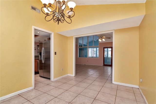 unfurnished dining area featuring light tile patterned flooring, vaulted ceiling, and ceiling fan with notable chandelier