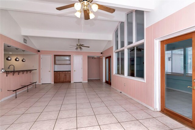 unfurnished living room featuring light tile patterned flooring, ceiling fan, and vaulted ceiling with beams