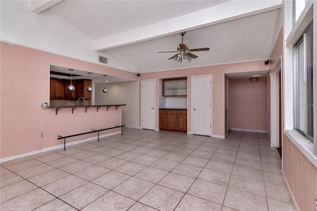 unfurnished living room featuring ceiling fan, sink, lofted ceiling with beams, and light tile patterned floors